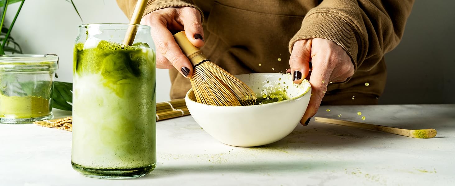 woman mixing ingredients for cna shaped drinking glass with straw and canister and bamboo on table