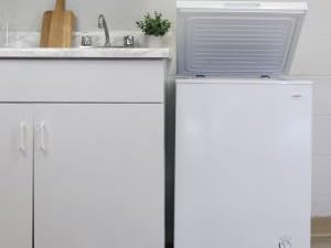 Koolatron white chest freezer, open, set up beside a white kitchen counter and sink