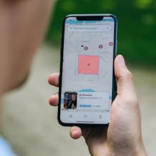 Man looking at phone with lojack geofence on smartphone app