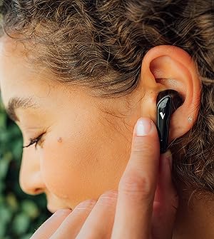Woman with earbud in ear and finger on earbud